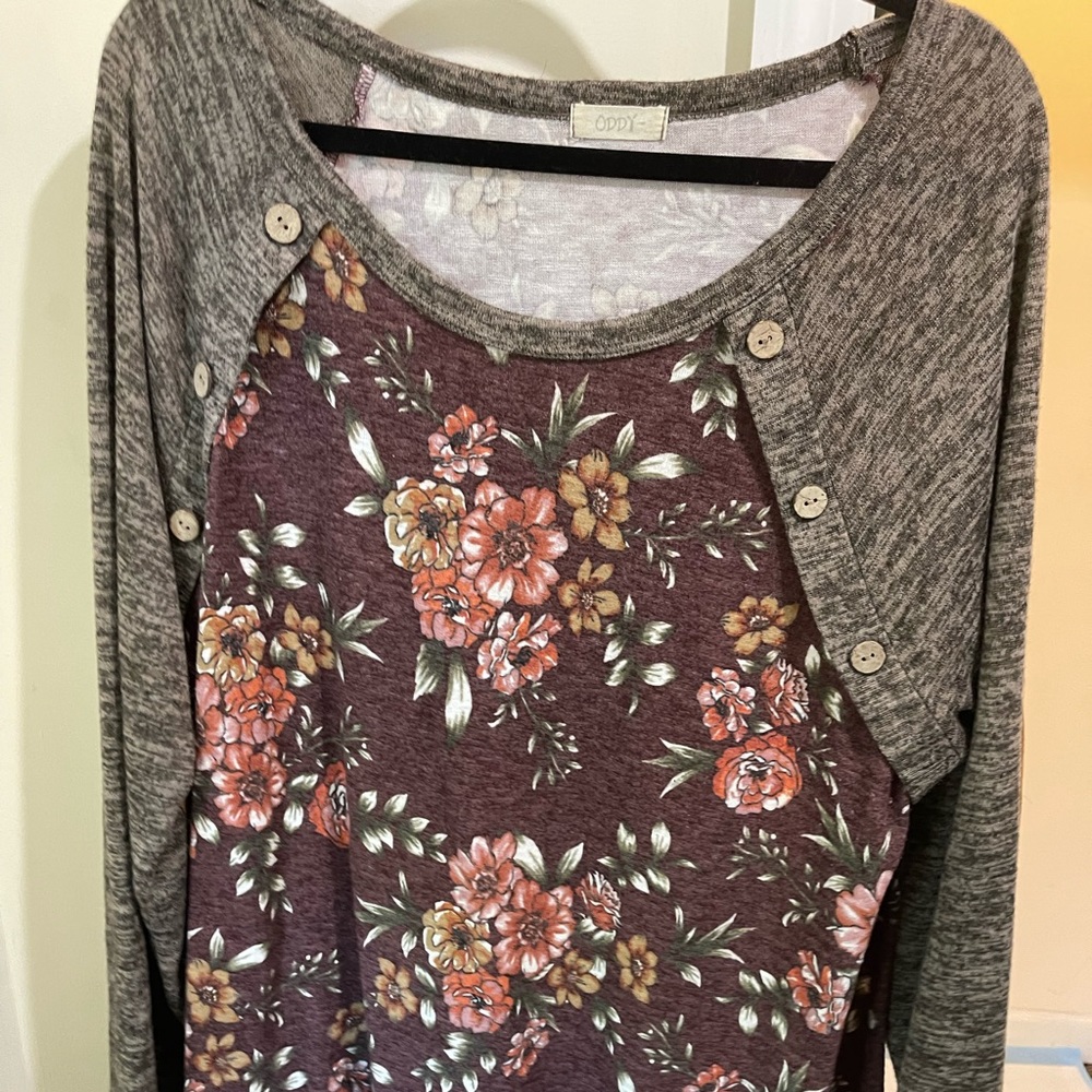 A tunic length top from a boutique size 3XL has button detailing.